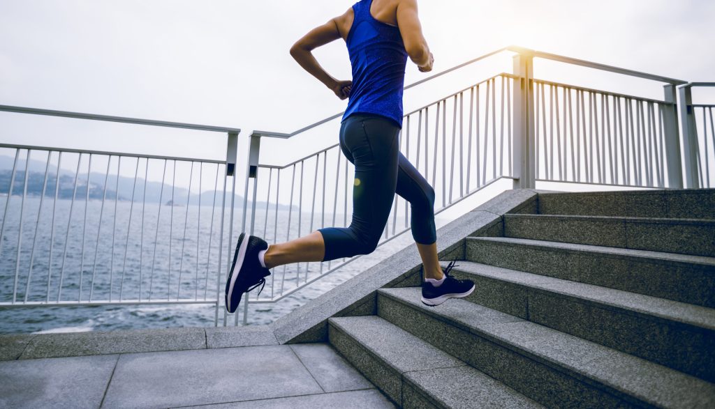Healthy lifestyle fitness sports woman runner running on seaside trail
